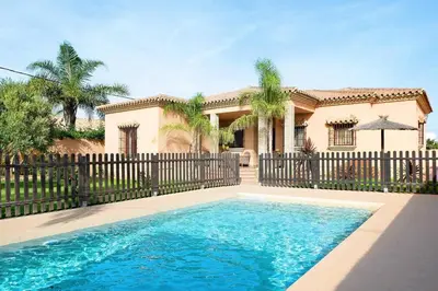 a house with a swimming pool in front of a fence at Casa Borpa - Solo Familias in Conil de la Frontera