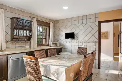 a kitchen with a table and chairs in a room at Casa Borpa - Solo Familias in Conil de la Frontera