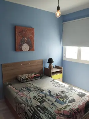 a bedroom with a bed and a painting on the wall at Casa Ana in Jerez de la Frontera