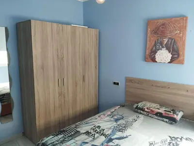 a bedroom with a bed and a wooden cabinet at Casa Ana in Jerez de la Frontera