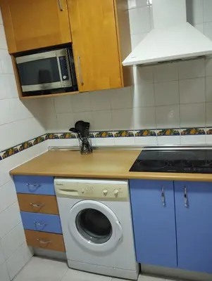 a kitchen with a washing machine and a microwave at Casa Ana in Jerez de la Frontera