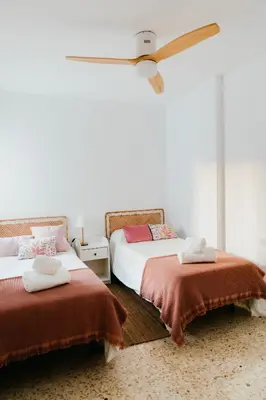 a bedroom with two beds and a ceiling fan at Casa Bahía in El Puerto de Santa María
