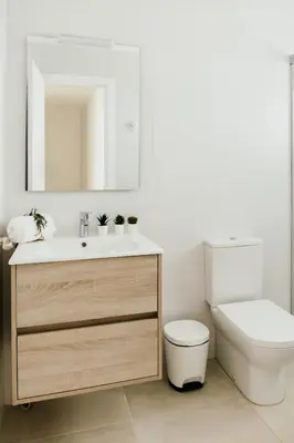 a bathroom with a sink and a toilet and a mirror at Casa Bahía in El Puerto de Santa María