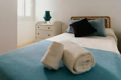 a bedroom with a bed with towels on it at Casa Bahía in El Puerto de Santa María