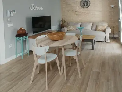 a living room with a table and chairs and a couch at casa la zarzamora in Jerez de la Frontera