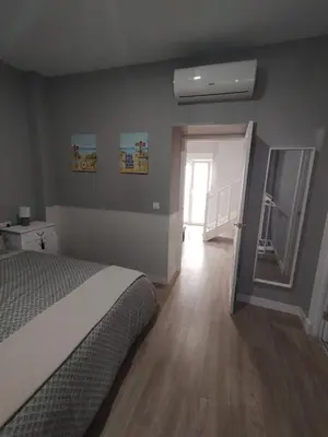 a bedroom with a bed and a hallway with a window at casa la zarzamora in Jerez de la Frontera