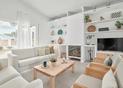 a living room with white furniture and a fireplace at Tío Pa - Tucasaenconil in Roche