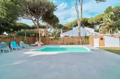 a swimming pool in a yard with chairs and a fence at Tío Pa - Tucasaenconil in Roche