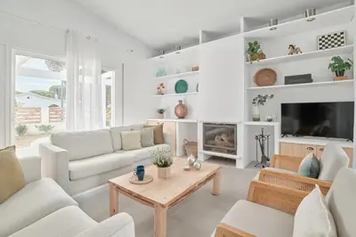 a living room with white furniture and a fireplace at Tío Pa - Tucasaenconil in Roche
