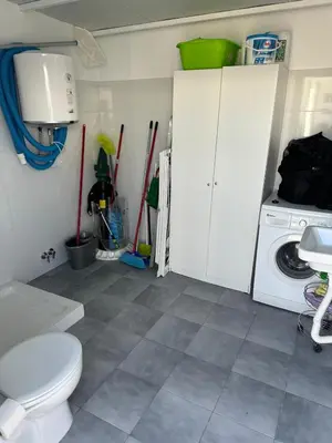 a bathroom with a toilet and a washing machine at Casa con piscina Sanlúcar de Barrameda in Sanlúcar de Barrameda