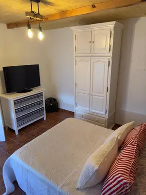 a living room with a bed and a tv at Casa con piscina Sanlúcar de Barrameda in Sanlúcar de Barrameda