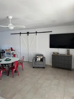 a living room with a tv and a table and chairs at Casa con piscina Sanlúcar de Barrameda in Sanlúcar de Barrameda