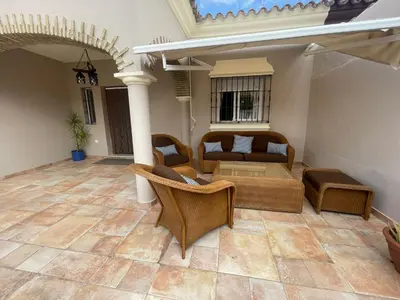 a living room with a couch and chairs on a patio at Villa Bolet in Chiclana de la Frontera