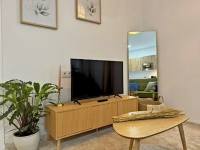 a living room with a flat screen tv on a dresser at Apartamento Clavel - Ole Solutions in Jerez de la Frontera