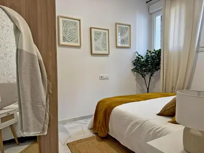 a bedroom with a bed and two pictures on the wall at Apartamento Clavel - Ole Solutions in Jerez de la Frontera