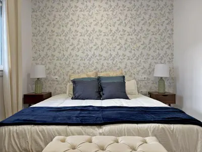 a bedroom with a large bed with blue pillows at Apartamento Clavel - Ole Solutions in Jerez de la Frontera
