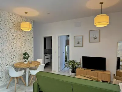 a living room with a green couch and a table at Apartamento Clavel - Ole Solutions in Jerez de la Frontera