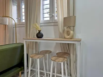 a bar with stools in a room with windows at Apartamento Clavel - Ole Solutions in Jerez de la Frontera