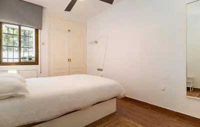 a white bedroom with a bed and a window at Pet Friendly Apartment in El Puerto de Santa María