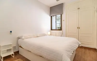 a white bedroom with a large bed and a window at Pet Friendly Apartment in El Puerto de Santa María