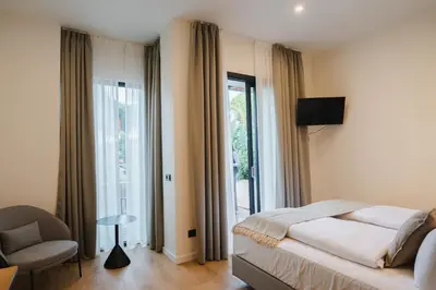 a bedroom with a bed and a chair and a window at Casa Cuatro Boutique Hotel - Adults Recommended in Novo Sancti Petri