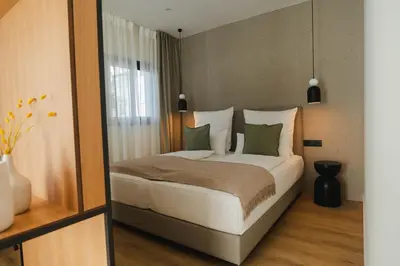 a bedroom with a bed with white sheets and green pillows at Casa Cuatro Boutique Hotel - Adults Recommended in Novo Sancti Petri