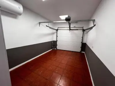 an empty garage with a white door and a wooden floor at Casa Moderna con Garaje en Rota, cerca de Playa in Rota