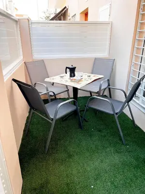 a table and chairs on a balcony with green grass at Casa Moderna con Garaje en Rota, cerca de Playa in Rota