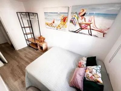 a bedroom with a bed and two paintings on the wall at Casa Moderna con Garaje en Rota, cerca de Playa in Rota