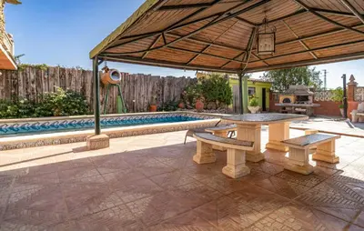 a patio with a picnic table and an umbrella at Stunning Home In Chiclana De La Fronter in Novo Sancti Petri