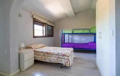 two beds in a room with two bunk beds at Stunning Home In Chiclana De La Fronter in Novo Sancti Petri