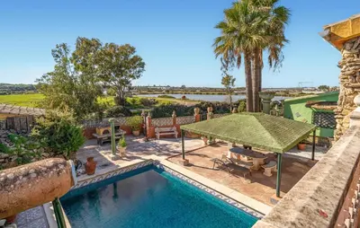 an outdoor swimming pool with a table and a patio at Stunning Home In Chiclana De La Fronter in Novo Sancti Petri