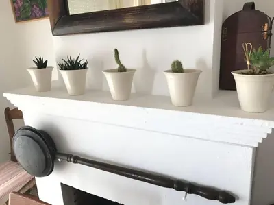a white fireplace mantle with potted plants on it at Apartamento primera linea de playa in Rota