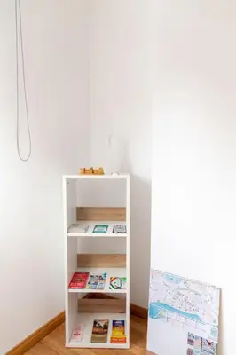 a white book shelf next to a white wall at Norte y Sur by Gades Gestión in San Fernando