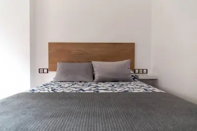 a bedroom with a bed with a wooden headboard at Norte y Sur by Gades Gestión in San Fernando