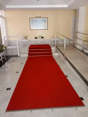 a red carpet in a large room with stairs at Apartamento Calzada Centro, Calle Hermano Fermín in Sanlúcar de Barrameda