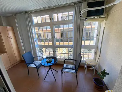 a room with a table and chairs and a large window at Apartamento Calzada Centro, Calle Hermano Fermín in Sanlúcar de Barrameda