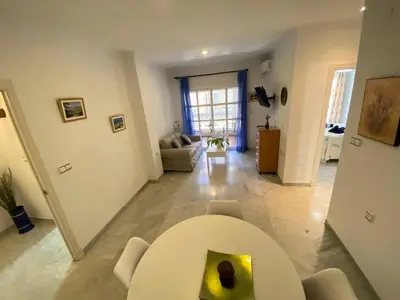 a living room with a white table and chairs at Apartamento Calzada Centro, Calle Hermano Fermín in Sanlúcar de Barrameda