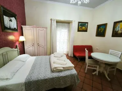 a bedroom with a bed and a table and a chair at Cielos Casona in El Puerto de Santa María