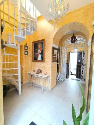 a hallway with a table and a chandelier at Cielos Casona in El Puerto de Santa María