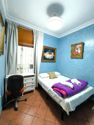 a bedroom with a bed and a desk and a chair at Cielos Casona in El Puerto de Santa María