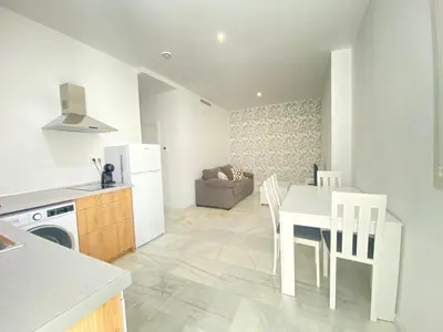 a kitchen and dining room with a white table and chairs at People Homes Clavel in Jerez de la Frontera