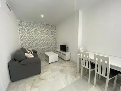 a living room with a couch and a table and a television at People Homes Clavel in Jerez de la Frontera