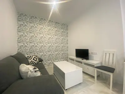 a living room with a couch and a desk with a television at People Homes Clavel in Jerez de la Frontera
