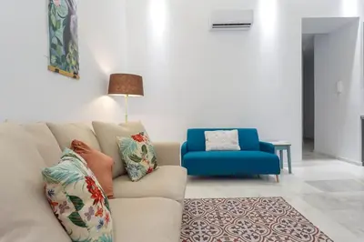 a living room with a couch and a blue chair at Apartamento Miracadiz in Cádiz