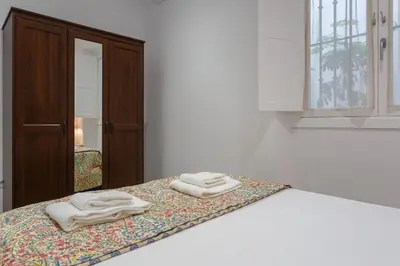 two towels sitting on top of a bed with a mirror at Apartamento Miracadiz in Cádiz