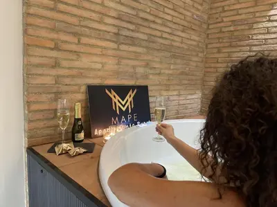 a woman sitting in a bath tub with glasses of wine at Winahost Algar Rural in Algar