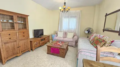a living room with a couch and a tv and a table at Chocita del Botánico Pet Friendly by Sanlúcar Housing in Sanlúcar de Barrameda