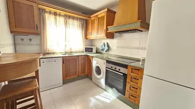 a kitchen with wooden cabinets and a washer and dryer at Chocita del Botánico Pet Friendly by Sanlúcar Housing in Sanlúcar de Barrameda