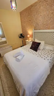 a bedroom with a large white bed with two pillows at Chocita del Botánico Pet Friendly by Sanlúcar Housing in Sanlúcar de Barrameda